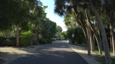Güneşli Florida 'da Casey Key manzaralı yolda POV sürüyor.
