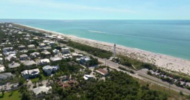 Boca Grande, Florida mimarisi. Beyaz deniz feneri kulesi ve yeşil palmiye ağaçları arasında pahalı rıhtım evleri olan zengin bir mahalle. ABD Premium Konutlarının Geliştirilmesi.