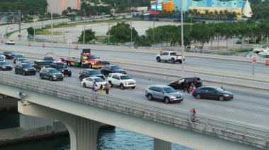 Miami 'de araba kazası. Yaralı sürücü ambulansın gelmesini bekliyor. Sokakta kaza kurbanlarına yardım eden insanlar. Köprü yolundaki araç kazasına ilk müdahale ekipleri yardım ediyor..