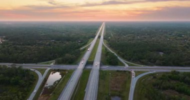 ABD 'de çok şeritli otoyol kavşağında hızlı sürüş yapan arabalar var. Florida ulaşım altyapısının üstü..