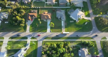 Florida 'daki küçük Amerikan kasabasında kırsal yol trafiği. Yeşil ağaçlar ve sakin yerleşim alanlarındaki banliyö sokakları arasında özel evler var.