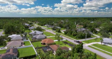 Florida 'daki küçük Amerikan kasabasında trafik arabaları süren kırsal yol. Sakin yerleşim bölgesinde yeşil ağaçlar ve banliyö sokakları arasında özel evler