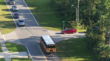 Okul otobüsü, banliyö otobüs durağındaki dersleri için çocukları alıyor. ABD 'de toplu taşıma