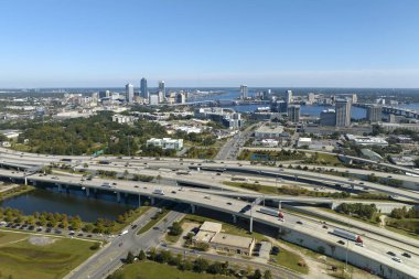 Jacksonville şehrinin hava manzarası. Yüksek ofis binaları ve hızlı araba ve kamyonlarla Amerikan otoyolu kavşağı. ABD ulaşım altyapısının üstünden görüntüle.