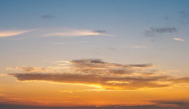 Parlak günbatımı, parlak turuncu ve sarı bulutların ardında batan güneş..