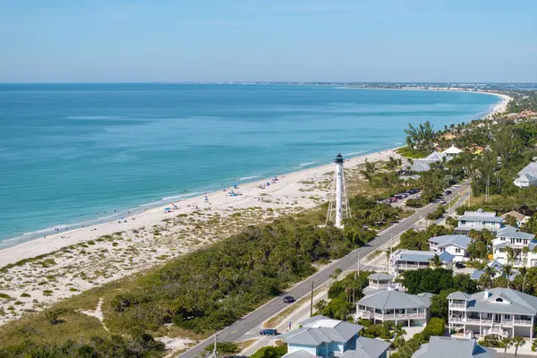 Florida 'nın güneybatısındaki Gasparilla Adası' ndaki Boca Grande adasında Amerikan rıhtım evleri ve beyaz deniz feneri..