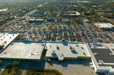 Park etmiş bir sürü arabası olan büyük bir otopark. Alışveriş merkezindeki büyük otopark. Araç yerleri ve yönleri için çizgiler ve işaretler var..