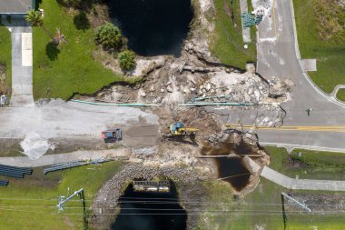 Yol yapımı. Kazıcı, Florida 'daki asfaltı sel baskınından sonra yıkılan köprüyü onardı. Yol çalışması alanında inşaat ekipmanları.