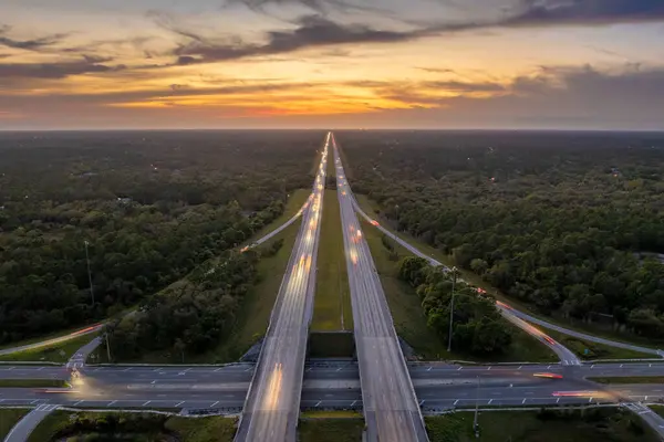 stock image Highway intersection in Florida rural area at sunset. Elevated interchange lanes for express passing of car traffic.