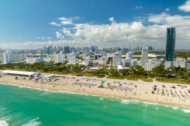Güney Sahili 'nin kumlu yüzeyi. Sıcak Florida güneşinde dinlenen turistler. Güney Amerika 'da turizm altyapısı. Yüksek lüks otelleri ve apartmanları olan Miami Beach City..