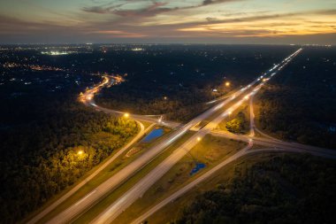 Gün batımında hızlı giden arabalarla Florida, ABD 'de geniş çoklu yol kavşağı. Amerikan ulaşım altyapısının üstü..