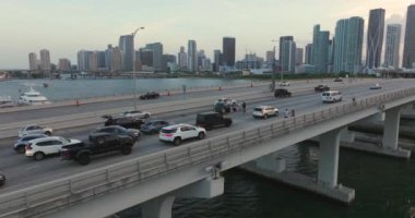 Köprü yolundaki araç kazasına ilk müdahale ekipleri yardım ediyor. Miami 'de araba kazası. Yaralı sürücü ambulansın gelmesini bekliyor. Sokakta kazazedelere yardım edenler.