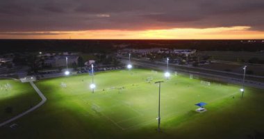 Geceleri çimen stadyumunda futbol oynayan çocuklarla halka açık spor parkı. Aktif yaşam konsepti.