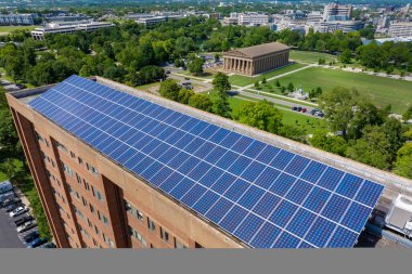 Solar çatılı bir apartman. Temiz ekolojik elektrik enerjisi üretmek için mavi fotovoltaik paneller. Yenilenebilir elektrik kavramına yatırım.