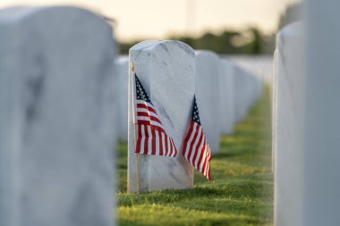 Beyaz mezar taşları ve Amerikan bayrağı olan eski ordu mezarlığı. Emekli askerlerin mezarları. Anma Günü konsepti.