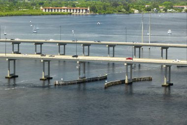 Barron Collier Bridge and Gilchrist Bridge in Florida with moving traffic. Transportation infrastructure in Charlotte County connecting Punta Gorda and Port Charlotte over Peace River. clipart