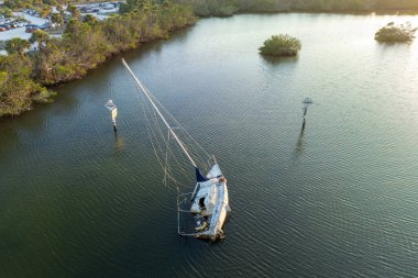 Manasota, Florida 'daki Ian kasırgasından sonra batık yelkenli teknesi sığ körfez sularında terk edildi..