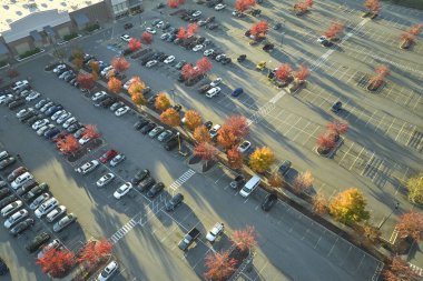 Otoparkta park yeri ve park yerleri için çizgiler ve işaretler olan bir sürü park etmiş aracın olduğu Amerikan marketinin manzarası. Bir alışveriş merkezinin önünde araçlar için yer.