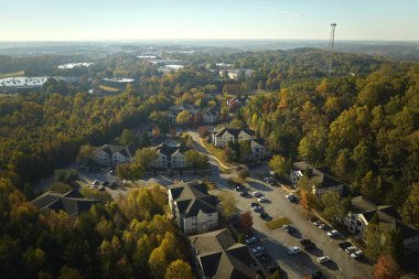 Güney Carolina 'nın banliyö bölgesindeki sarı sonbahar ağaçları arasındaki apartman dairelerinin üstünden bak. Amerikan banliyölerinde emlak gelişimine örnek olarak Amerikan evleri.