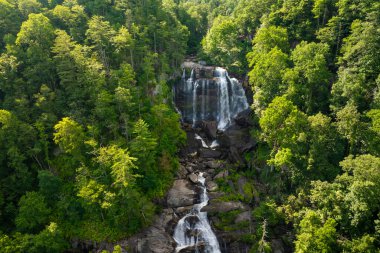 Whitewater Falls in Nantahala National Forest, North Carolina, USA. Beautiful landscape of high waterfall with falling down clear water from rocky boulders between green lush woods. clipart