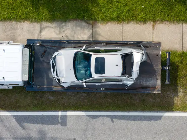 Çekici kamyon kaza yerinde parçalanmış araç taşıyor. Amerikan caddesindeki trafik kazasına acil servis personeli cevap veriyor. Amerika 'da ilk yardım ekipleri yolda..