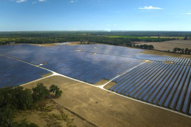 Temiz elektrik enerjisi üretmek için sıra sıra güneş fotovoltaik panelleri olan sürdürülebilir büyük elektrik santralinin havadan görünüşü. Sıfır emisyonlu yenilenebilir elektrik kavramı.