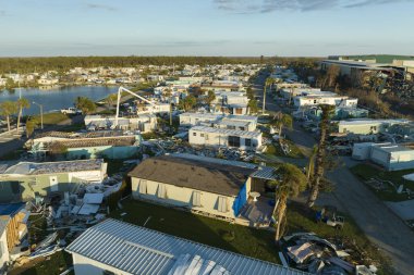 Hurricane strong wind destroyed suburban house roofs in Florida mobile home residential area. Consequences of natural disaster. clipart