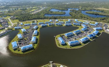 Çatıları sızdıran konutlar yağmur suyu sızıntılarına karşı koruyucu branda örtüleriyle kaplı, taa ki kiremitler değişene kadar. Florida 'daki kasırga sonrası çatıların hasar görmesi.