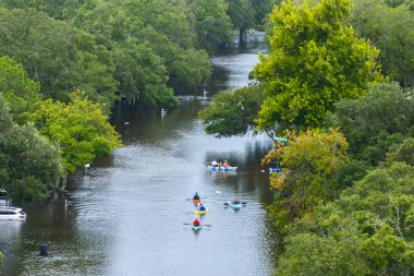 Aftermath of hurricane Debby flooding natural disaster. Kayak boats floating on flooded street surrounded by tropical storm rainfall flood waters homes in Sarasota, Florida residential area.