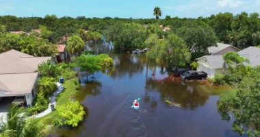 Debby kasırgası arasında kayak yapan kişi, Sarasota, Florida 'daki yerleşim birimlerinde evleri sular altında bıraktı. Doğal afetten sonra.
