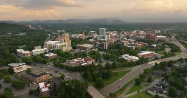 Kuzey Carolina 'daki Asheville şehrinin havadan görünüşü yüksek binalar ve günbatımında Appalachian dağ tepeleri. ABD seyahat hedefi.