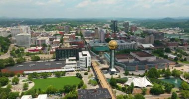 ABD 'nin Tennessee kentindeki Knoxville şehrinin şehir merkezindeki hava manzarası. Dünya Fuar Parkı 'ndaki güneş küresi ve modern Amerikan şehir merkezindeki yüksek gökdelen binaları.