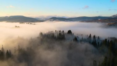 Tepedeki küçük köy evleri Sonbaharda sisli dağlarda gün doğumunda.