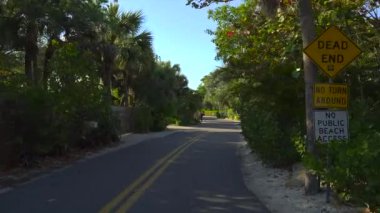Florida seyahat konsepti. Araba otomobili Casey Key manzaralı yolda tropikal doğa ve zengin sahil evleri ile ilerliyor.