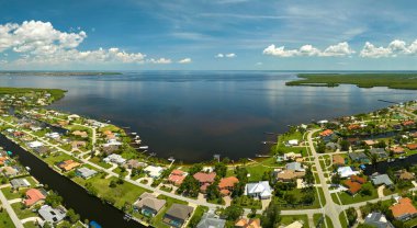 Körfez kıyısında, deniz kıyısında yeşil bitki örtüsü olan sulak alanlara yakın özel evleri olan yerleşim yerlerinin havadan görüntüsü. Doğa kavramına yakın yaşamak.