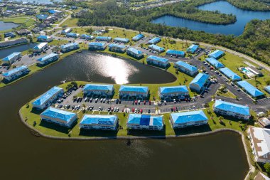 Daire çatıları, asfalt kiremitleri değişene kadar yağmur suyuna karşı mavi koruyucu muşambayla kaplı. Kasırga tarafından hasar verildi..