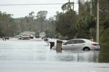 Kasırga sonrası Florida yerleşim bölgesinde kapana kısılmış bir araba ile sel basmış. Doğal afetin sonuçları..