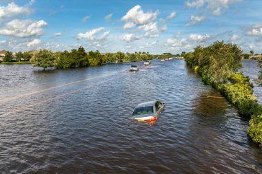 Hurricane rainfall flooded road. Drowned car on city street in Florida residential area. Consequences of hurricane natural disaster. clipart