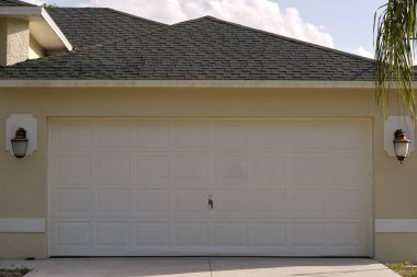 Geniş garaj, çift kapı ve modern Amerikan evinin beton yolu..