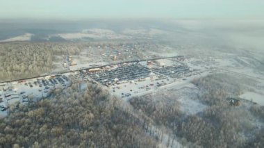 Satılık birçok arabanın hava manzarası ve kışın araba pazarında veya otoparkta yürüyen müşteriler..