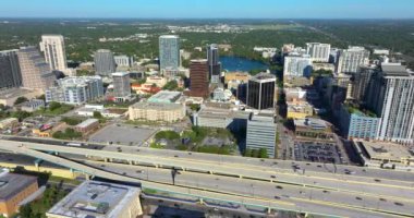 Orlando, Florida 'da hızlı sürüş yapan arabalarla kavşağın üzerinde gökdelen binaları olan Amerikan kentsel manzarası. ABD ulaştırma altyapısı.
