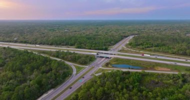 Gün batımında Florida kırsal kesiminde hızlı giden trafik arabalarıyla kavşak. ABD 'de eyaletler arası ulaşım altyapısı.