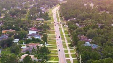 Florida 'da küçük bir kasabada araba süren kırsal sokak trafiği. Sakin yerleşim bölgesinde özel evleri olan Amerikan banliyö manzarası