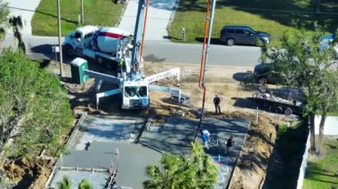 Yeni ev inşaatındaki işçiler duvar ve çatı için beton döşeme temelleri döşüyorlar..