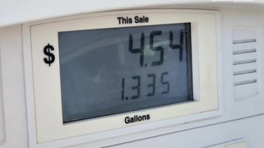 Benzin istasyonunun benzin pompası görüntüsü petrol maliyetini ve satın alınan galon miktarı gösteriyor.