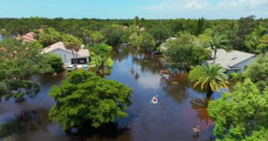 Debby Kasırgası kurbanları Florida, Sarasota 'da sel basmış bir sokakta kano kullanıyor. Yerleşim alanındaki kırsal evler arasında sağanak yağmur suları