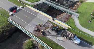Yol yapımı. Florida 'daki asfaltı sel baskınından sonra yıkılan köprüyü onaran işçiler. Yol çalışması alanında inşaat ekipmanları.