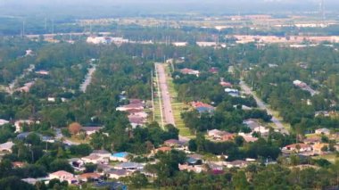 Florida 'daki küçük Amerikan kasabasında trafik arabaları süren kırsal yol. Sakin yerleşim bölgesinde yeşil ağaçlar ve banliyö sokakları arasında özel evler