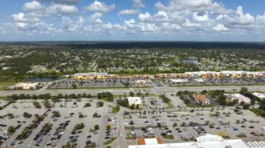 North Port, Florida 'daki American geniş yolu ve alışveriş merkezi plazası. Sürücü arabalı şehir trafiği. ABD ulaştırma altyapı kavramı