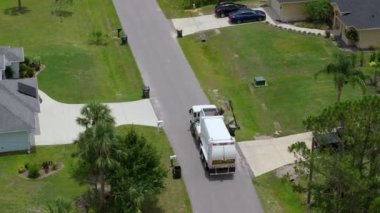 Otomatik modern çöp kamyonu Florida şehir caddesinde atık yüklüyor. Belediye hizmetleri